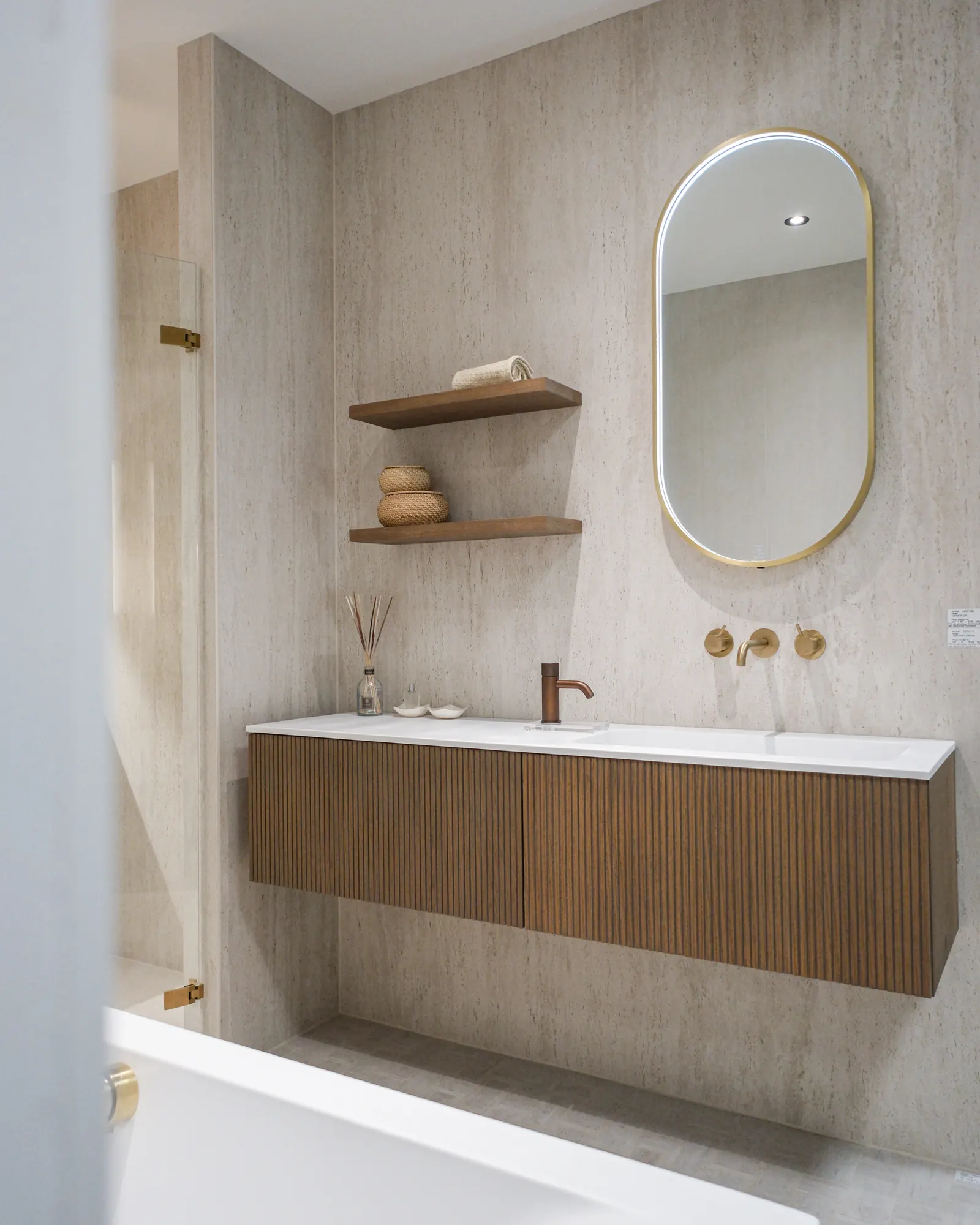 Badkamer met eiken badmeubel, ovale spiegel en messing kranen