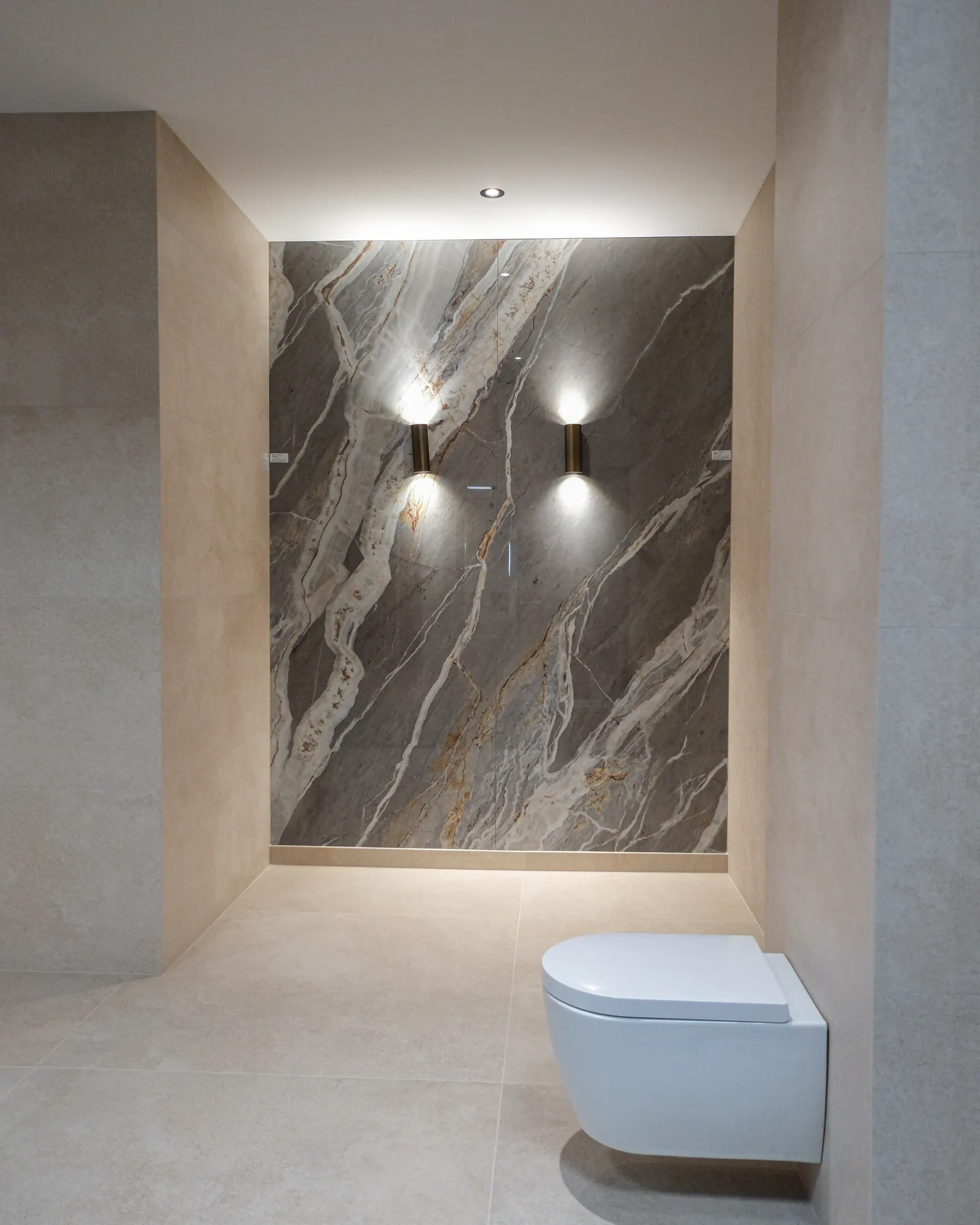 Marmerlook accentwand met wandlampen en hangtoilet